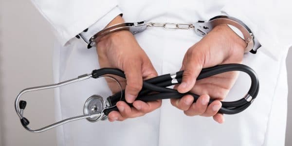 a doctor who is in handcuffs after being found guilty of intentional medical malpractice