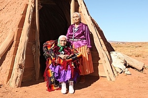 Elderly Native American women in front of hut 