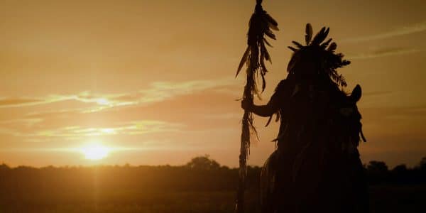 Tribal member on horseback looking at sunset