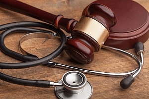 Stethoscope sitting with gavel on wrongful death suit