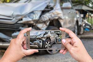 Hombre documentando evidencia después de estar en un accidente automovilístico