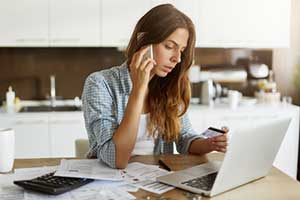 Woman calling her bank following the steps on what to do if you've been scammed