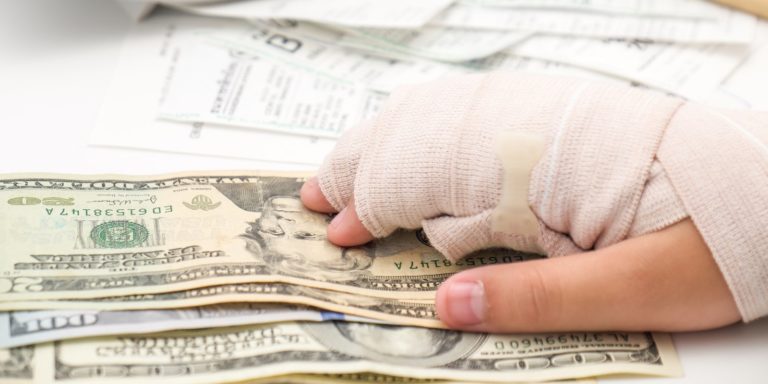 A car accident victim with broken hand and dollar bills