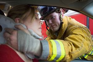 Firefighter helping an injured woman after a fatal car accident