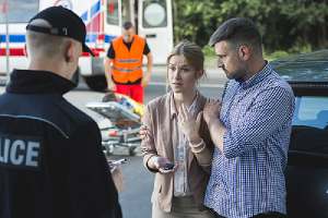 Policeman obtaining information from witnesses of a car accident