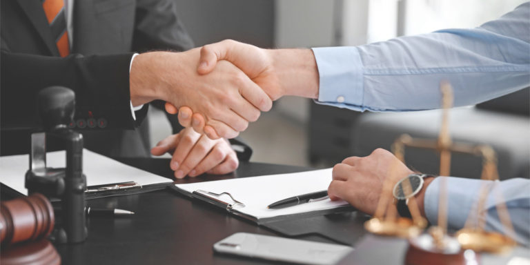 client and the legal counsel shake hands before conversing about the personal injury case