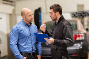 mechanic explains to customer the charges to allay the customer fear of an overbilling scheme